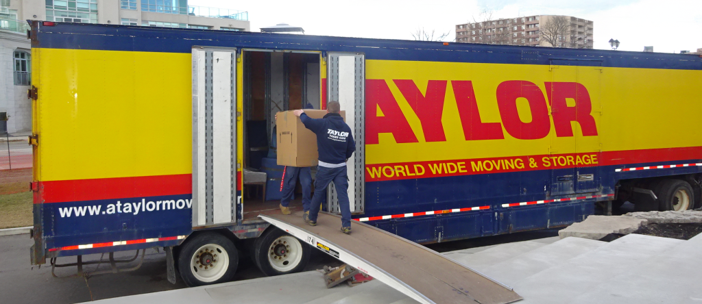 Movers loading boxes on Taylor moving truck