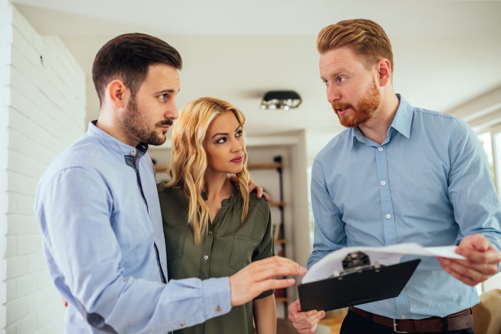 Man showing a couple information an a clipboard