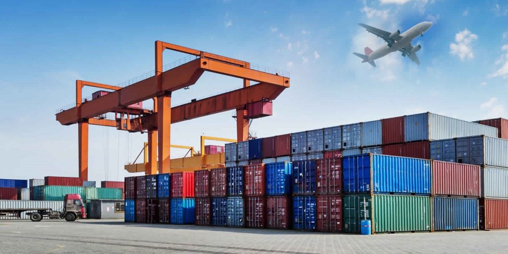 Containers at port with flatbed truck and cargo plane